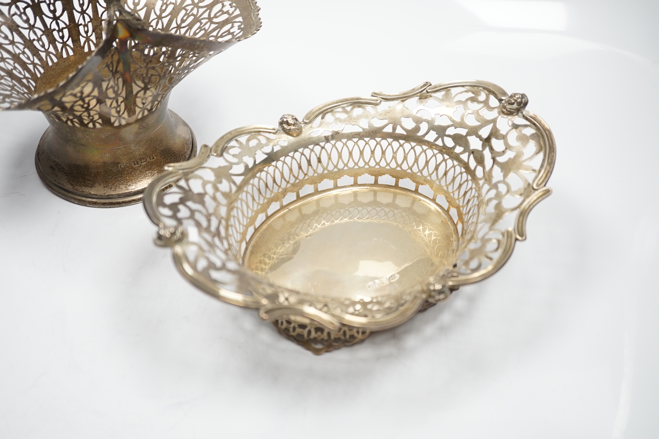 A George V pierced silver basket, Henry Matthews, Birmingham, 1914, height 23.7cm, together with a pierced silver oval dish, London, 1912, 14.1oz.